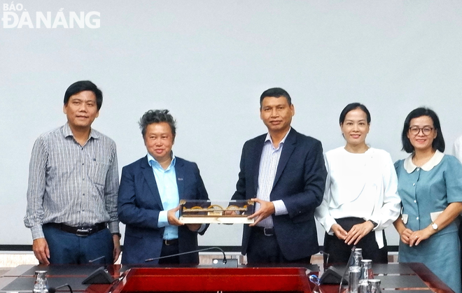 ホー・キ・ミン市人民委員会常任副委員長（中央）が、シンガポールビジネス連盟の代表者に記念品を贈呈している。写真：M.Q