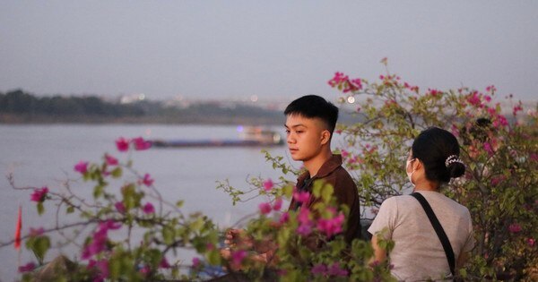 Junge Leute laden sich gegenseitig ein, an einem neuen, extrem entspannten Aussichtspunkt für den Sonnenuntergang in Hanoi einzuchecken