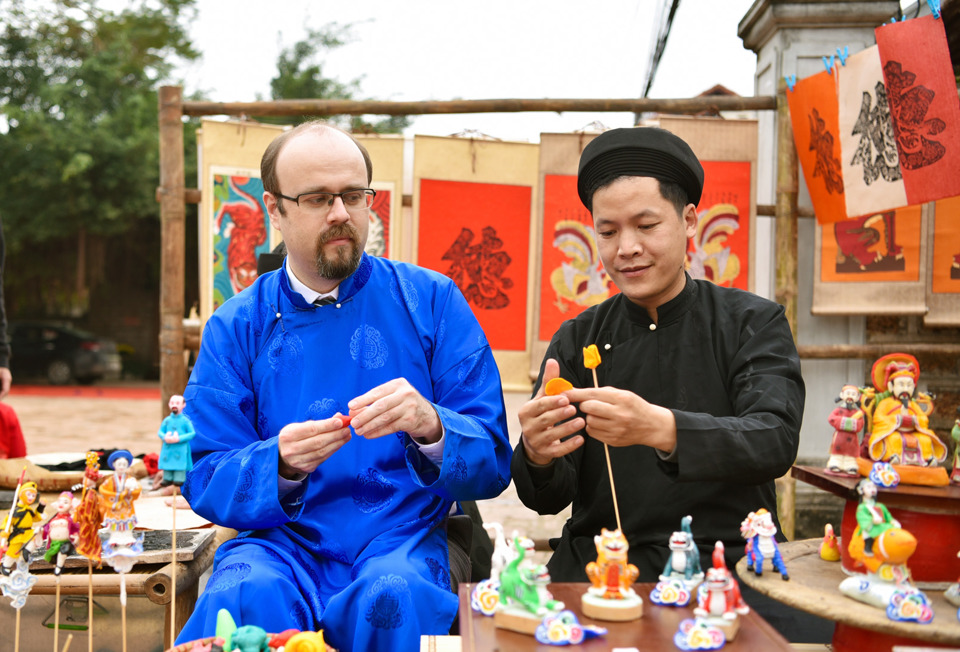 International tourists experience the traditional Vietnamese New Year at Duong Lam ancient village (Son Tay). Photo: Hoai Nam