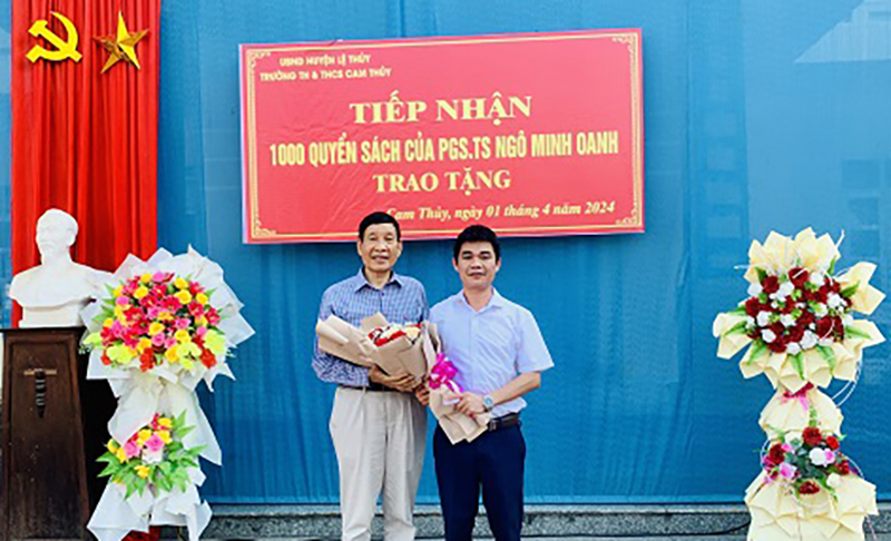 Associate Professor, Dr. Ngo Minh Oanh (left cover) at the book donation ceremony in Cam Thuy commune (Le Thuy).