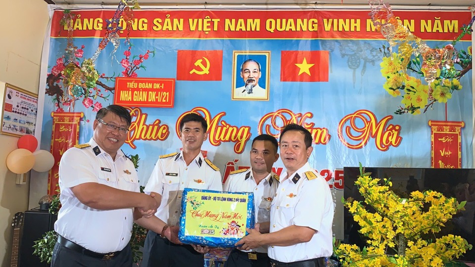 Đại tá Vũ Duy Lưu, Phó Chủ nhiệm chính trị, Bộ Tư lệnh Vùng 2 hải quân (ngoài cùng bên phải) và Thượng tá Triệu Thanh Tùng, Trưởng đoàn công tác tàu Trường Sa 21 (ngoài cùng bên trái) trao quà Tết tới cán bộ, chiến sĩ Nhà giàn DKI/21 - Ảnh: Vân Hà