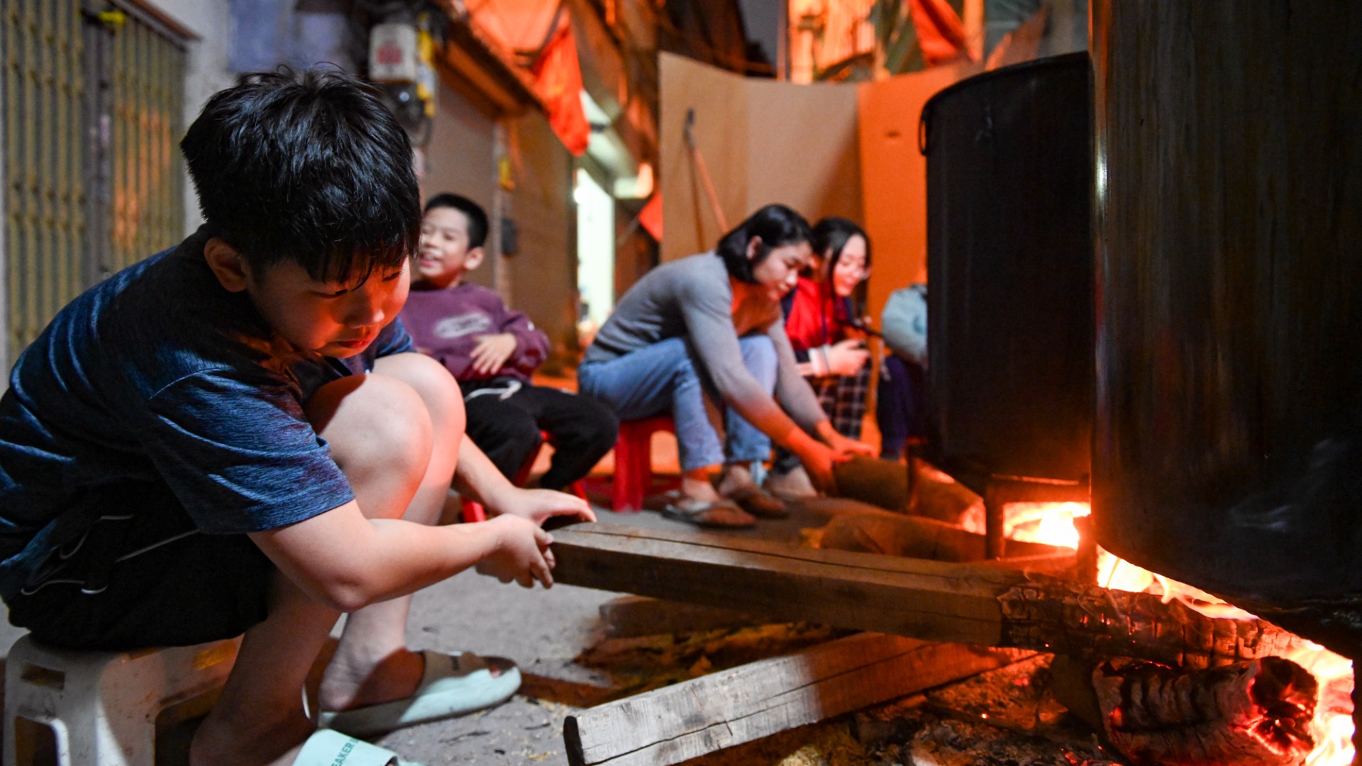 La famille se réunit et reste debout toute la nuit pour surveiller le pot de banh chung du Têt