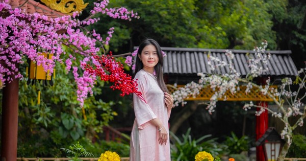 Una joven toma fotografías del Tet en una pagoda sagrada en Nghe An