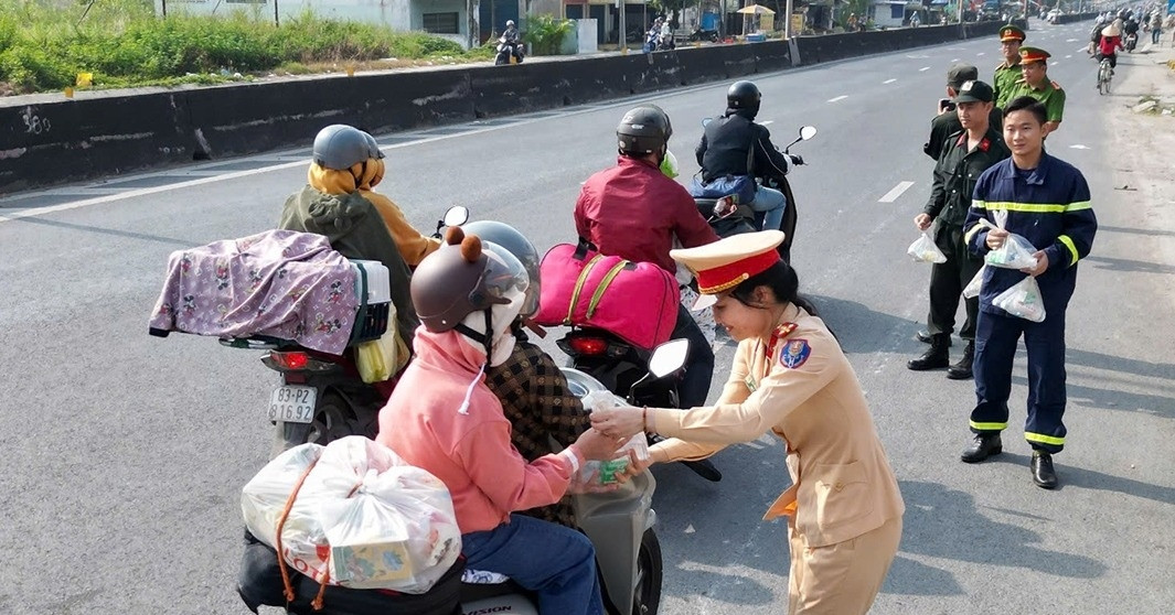 Traffic police in the West give out bread, milk, and mineral water to people returning home for Tet.