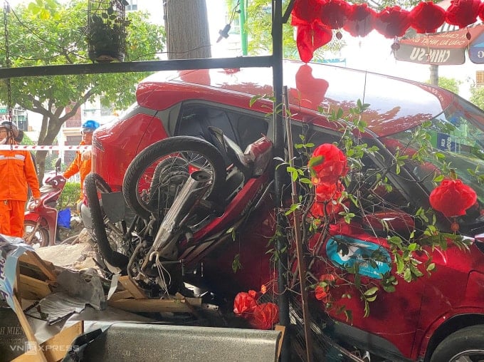 Part of the motorbike lying under the car caused the accident. Photo: Dinh Van