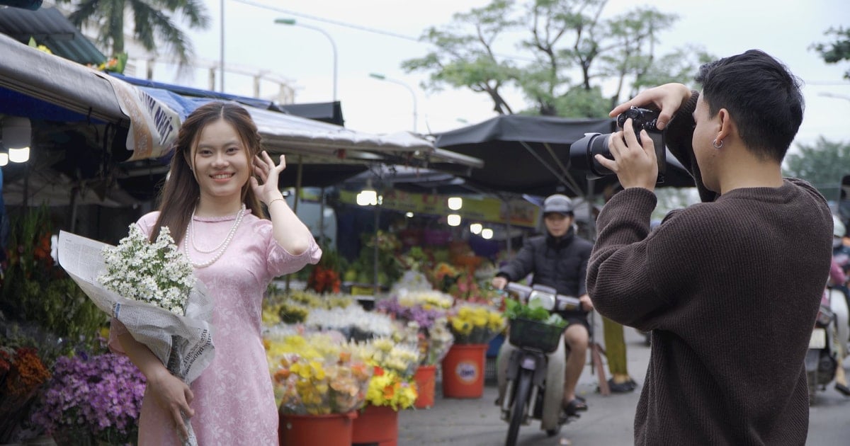 คนหนุ่มสาวสวมชุดประจำชาติเวียดนามถ่ายรูปฤดูใบไม้ผลิ