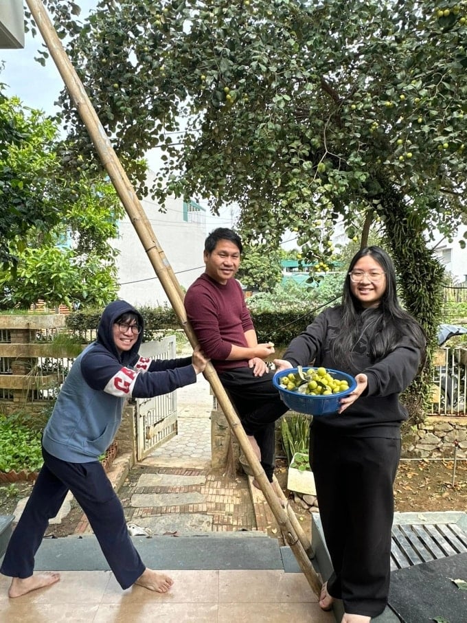 Trong Tan et ses deux enfants cueillent des pommes. Photo : Personnage fourni