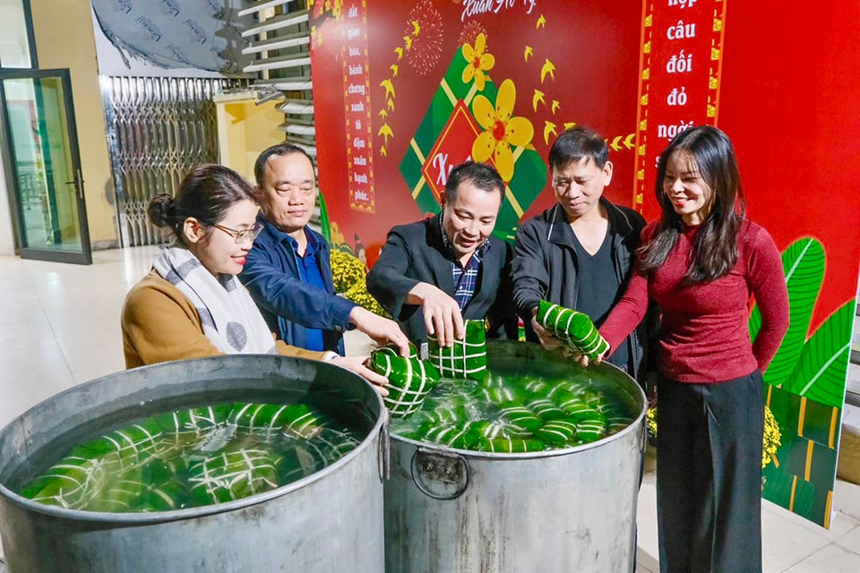 La Dra. Mai Trong Hung, del Hospital de Obstetricia de Hanoi, y su personal se unen para encender un fuego ardiente para hervir banh chung.