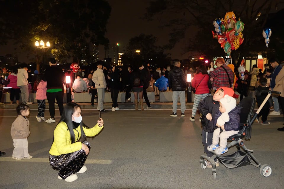 サーダン湖（ドンダー地区）の花火会場14番地では、新年を告げる華やかな花火を待ちわびる人々が集まり、会場は興奮と興奮に包まれました。多くの家族連れが子供たちを連れて、2025年の巳年を迎える喜びを噛み締めていました。写真：カム・トゥ