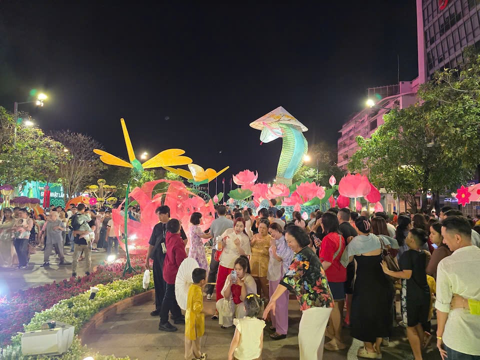 グエンフエ・フラワーストリート（ホーチミン市1区）はほぼ人で溢れかえっている。多くの人が花火を見に場所を選び、大晦日を待ちわびている。写真：ハ・ナム