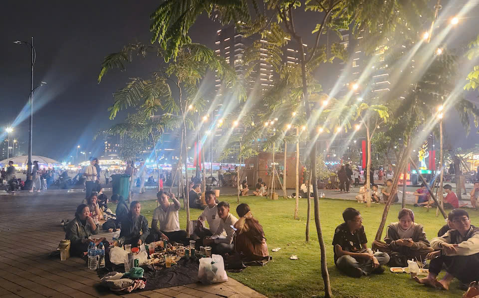 午後10時を過ぎると、多くの人がバクダン埠頭公園（ホーチミン市1区）で花火を見るために席を選びました。ここは、2025年の新年を迎える花火を鑑賞するのに最高の場所と考えられています。写真：ティウ・トゥイ