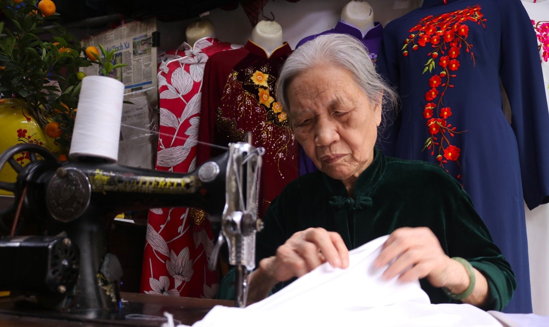 Ibu Quyen dengan tekun menjahit ao dai (pakaian tradisional Vietnam) untuk para pelanggannya (foto oleh Trung Nguyen).