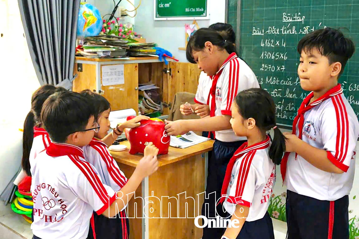 Học sinh Trường Tiểu học Phủ Hà 2 (phường Phan Rang) nuôi heo đất giúp bạn nghèo.