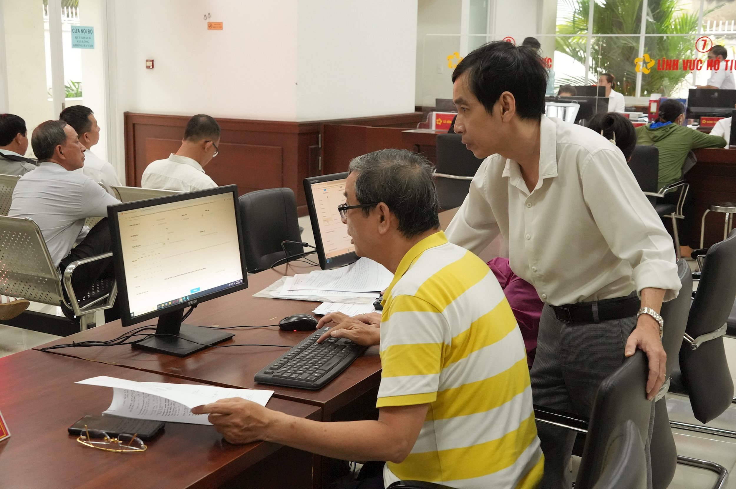 Staff of the Phu Nhuan Ward Public Administration Service Center guide people to declare online on the National Public Service Portal using free computers arranged by the Center.