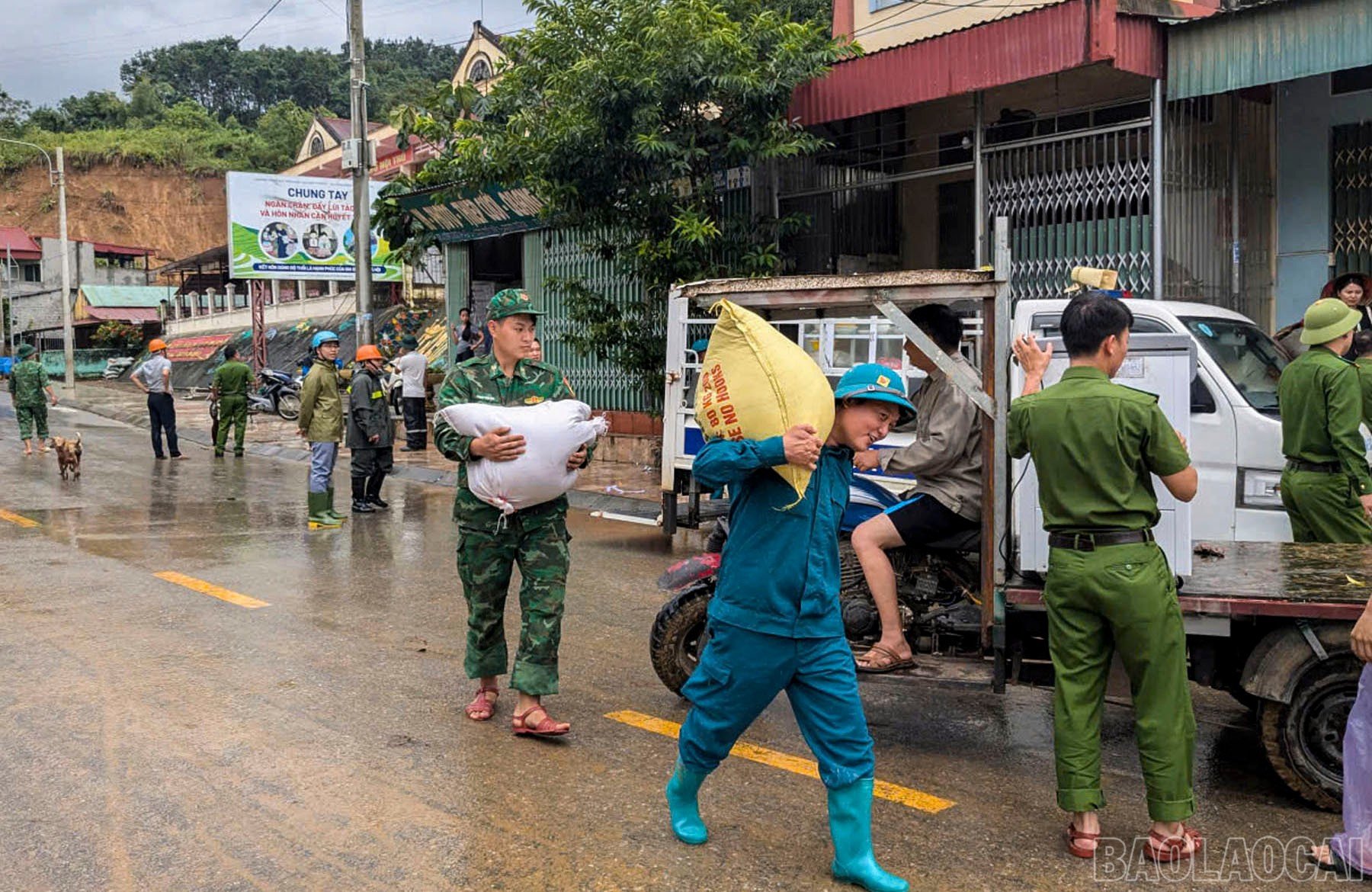 Các lực lượng giúp người dân tại khu vực sạt lở di chuyển tài sản đến nơi an toàn.