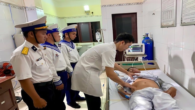 Doktor tentera dari Rumah Sakit Pulau Truong Sa memeriksa kesihatan pesakit Nguyen Van Cha. (Foto: wartawan HQ)