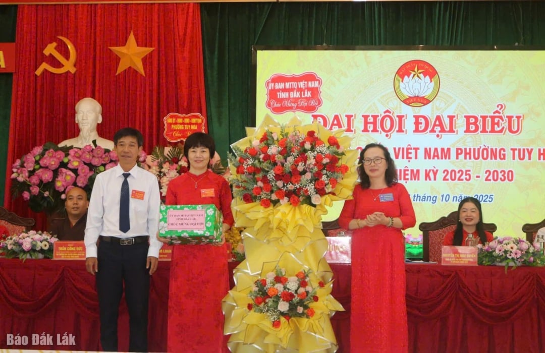 សមមិត្ត Pham Thi Ngoc Tuyet អនុប្រធានគណៈកម្មាធិការមជ្ឈិមរណសិរ្សមាតុភូមិវៀតណាមខេត្ត (គម្របខាងស្តាំ) ជូនកម្រងផ្កាអបអរសាទរមហាសន្និបាត។
