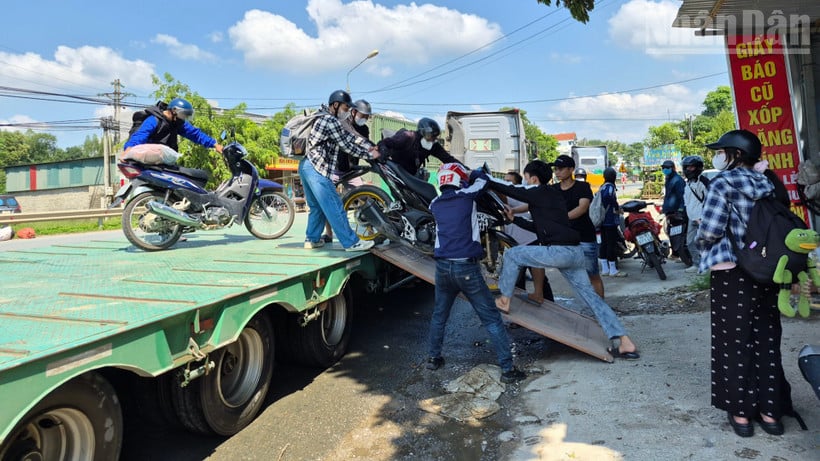 Các phương tiện xe máy được kéo lên xe đầu kéo để vượt qua các điểm ngập úng.