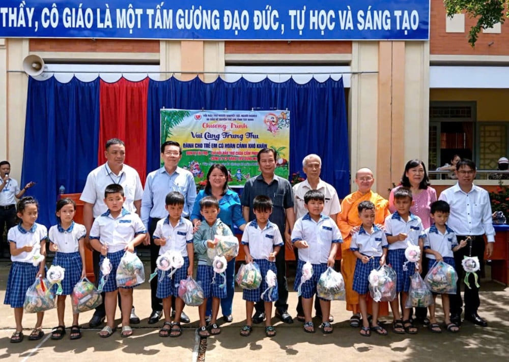 Lãnh đạo Sở Giáo dục – Đào tạo tỉnh và các thành viên trong đoàn tặng quà cho các em học sinh có hoàn cảnh khó khăn