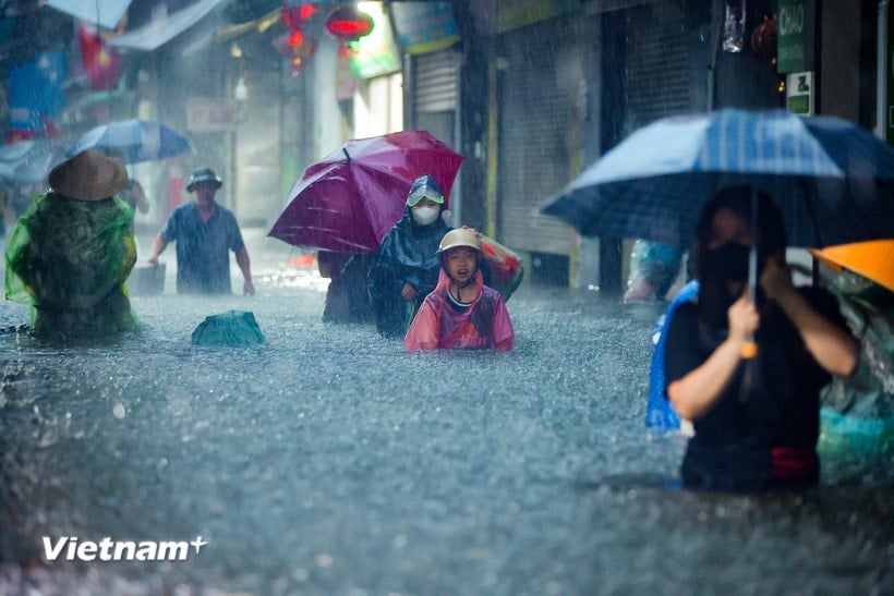Menschen in der Hauptstadt wateten am 30. September 2025 im starken Regen durch Wasser. (Foto: Hoai Nam/Vietnam+)