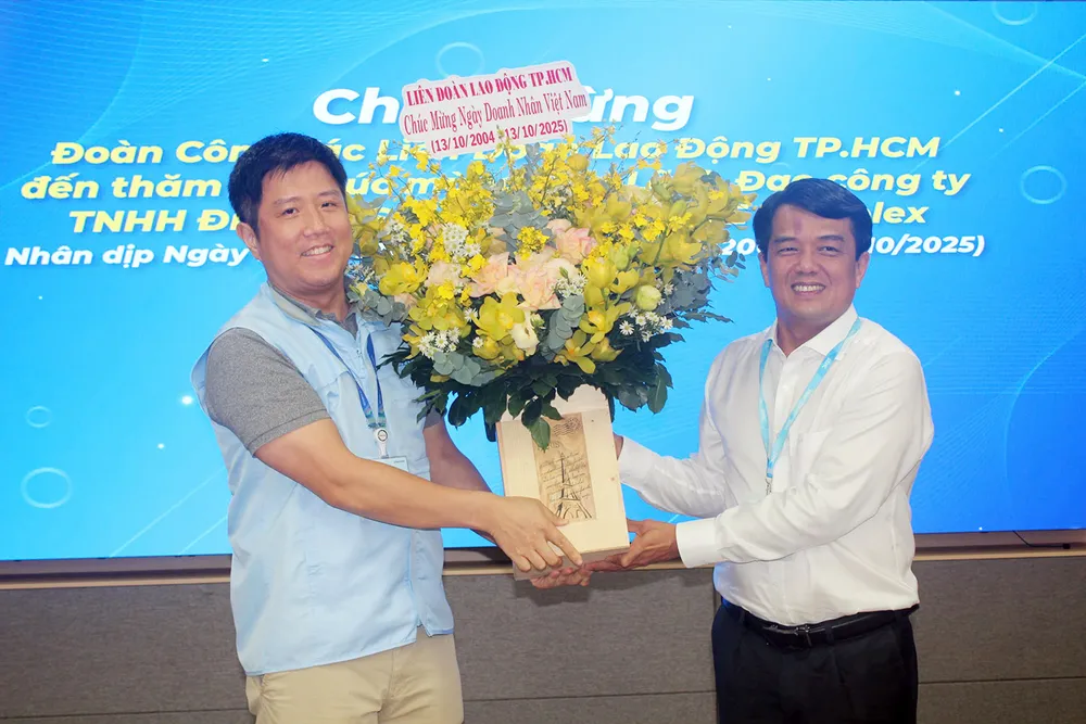 Kamrat Bui Thanh Nhan (höger omslag) överlämnar blommor till representanten för Samsung Electronics HCMC CE Complex Co., Ltd.