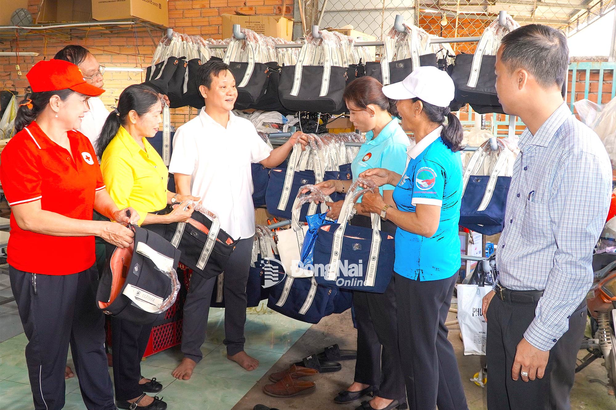 Đoàn cán bộ địa phương đến tham quan mô hình may gia công túi xách tại khu phố Bảo Vinh A. Ảnh: An Nhơn