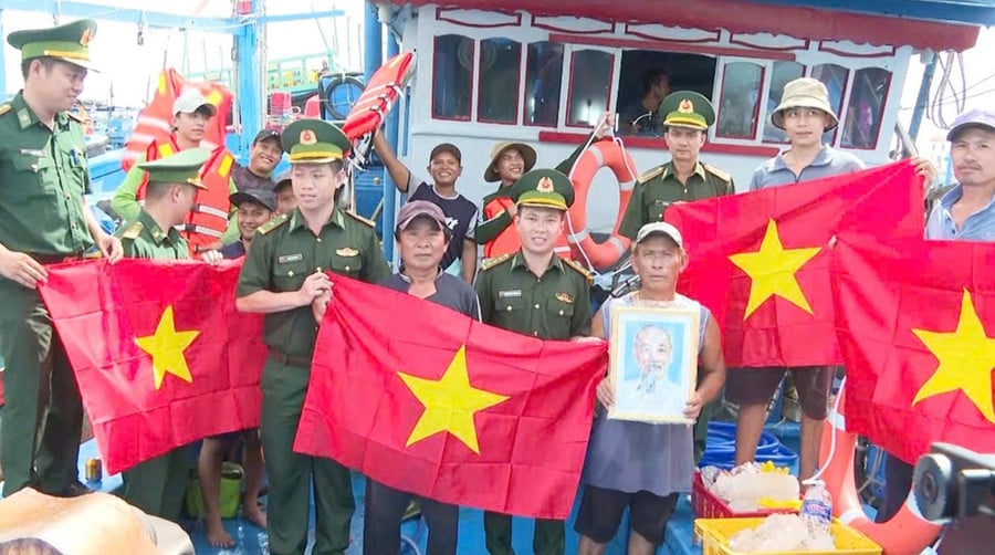 Bộ đội Biên phòng tỉnh Gia Lai tặng cờ Tổ quốc và ảnh Bác Hồ cho ngư dân. Ảnh: C.Cường