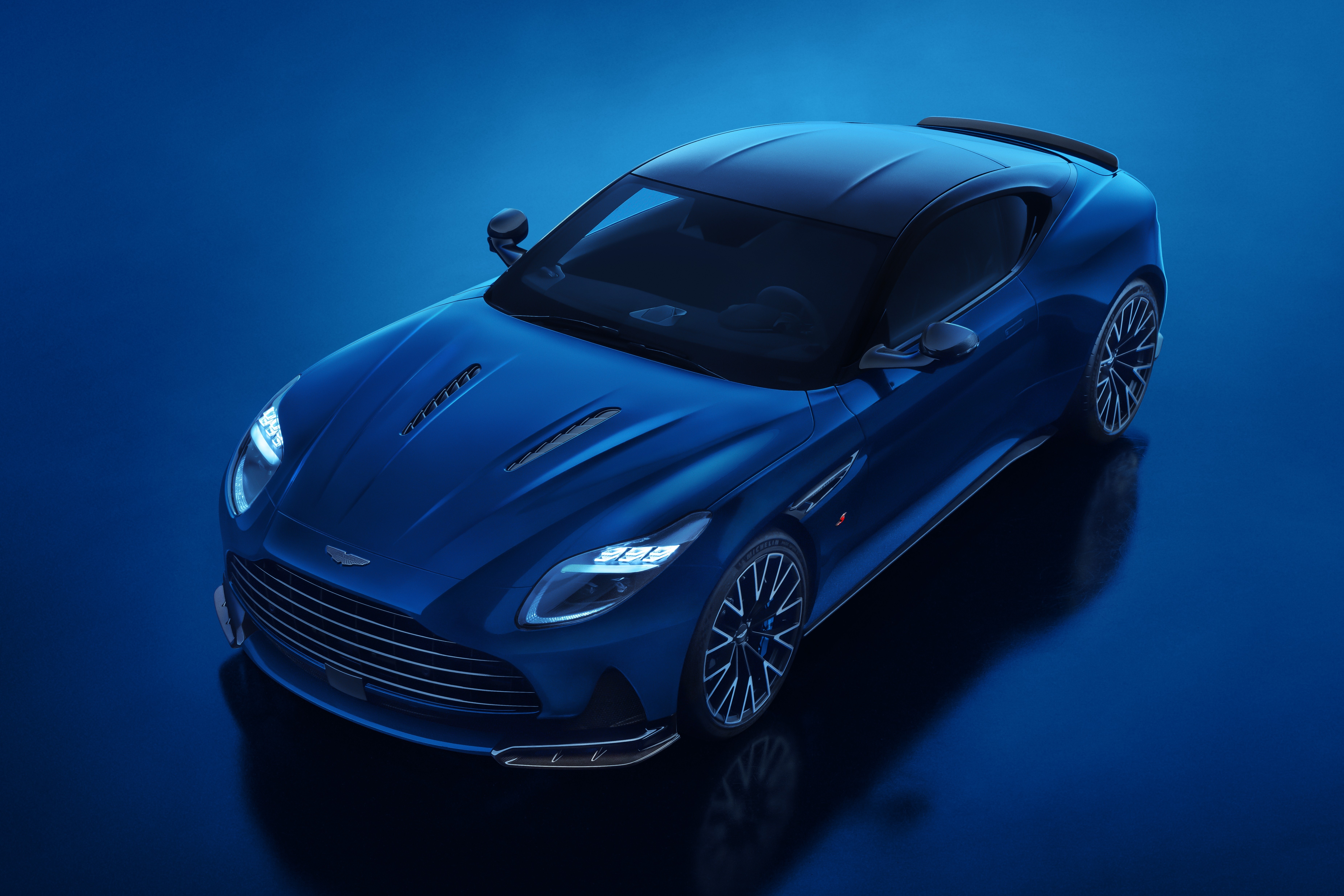 منظر بانورامي لسيارة أستون مارتن DB12 S بطلاء Ion Blue وتفاصيل ديناميكية هوائية جديدة.