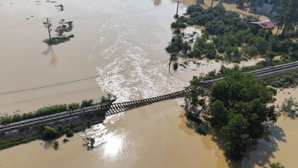 Het overstromingswater van de rivier Cau is de spoorlijn binnengedrongen en is nog niet teruggetrokken in de gemeente Trung Gia (stad Hanoi).