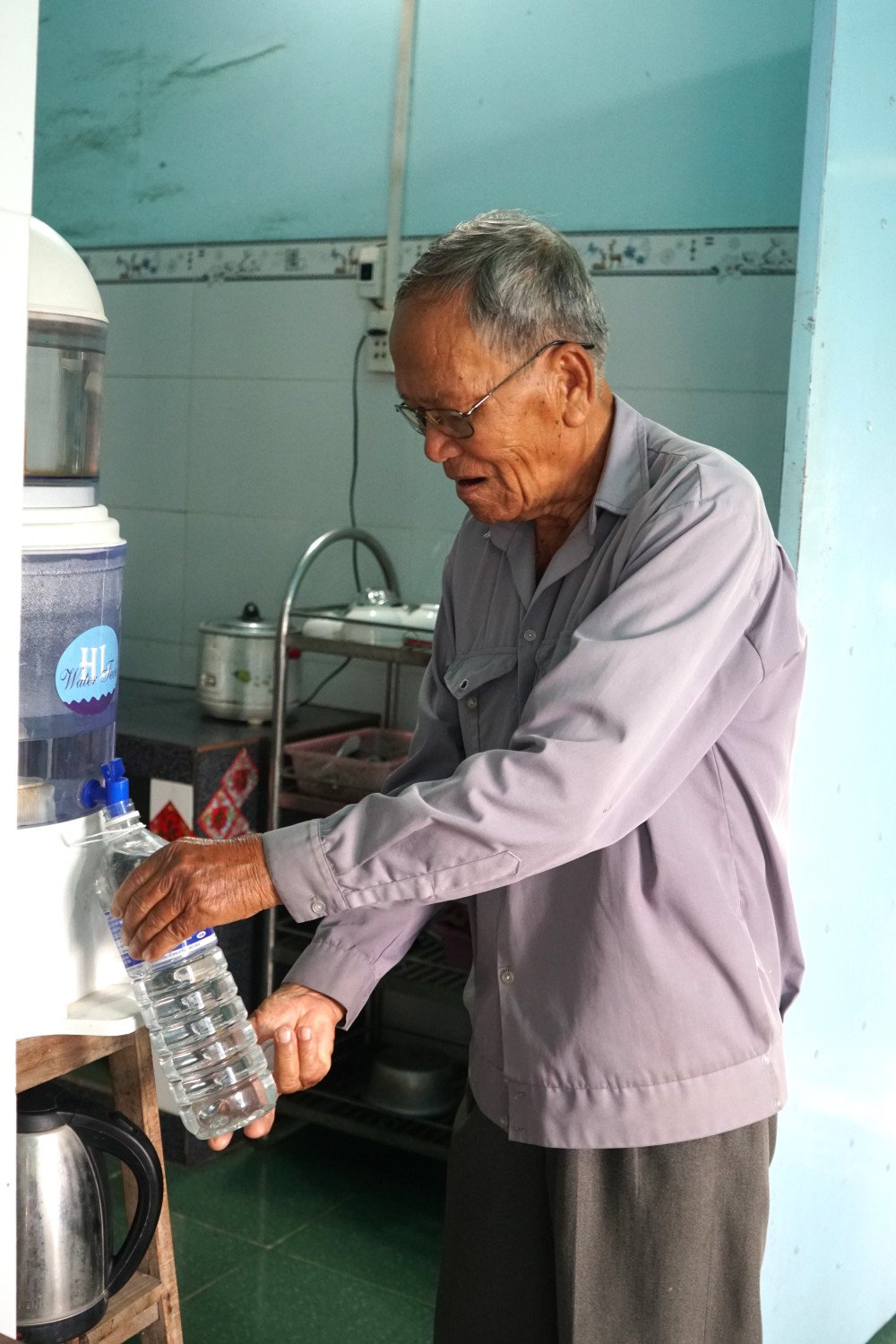Hằng ngày, ông Lực phải lọc từng chai nước như thế này để tắm