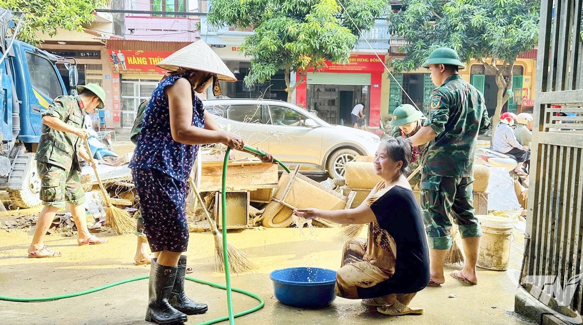 Warga kecamatan Phan Dinh Phung saling membantu membersihkan rumah mereka setelah badai dan banjir.