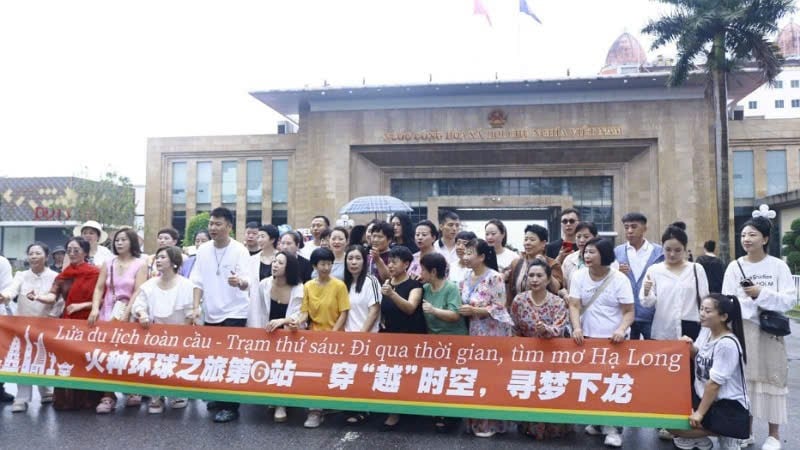 En grupp kinesiska turister tar souvenirfoton vid Mong Cai internationella gränsport i Quang Ninh.
