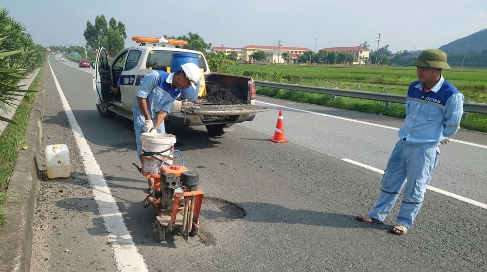 Memperbaiki kerusakan jalan akibat banjir di jalan raya Noi Bai - Lao Cai.