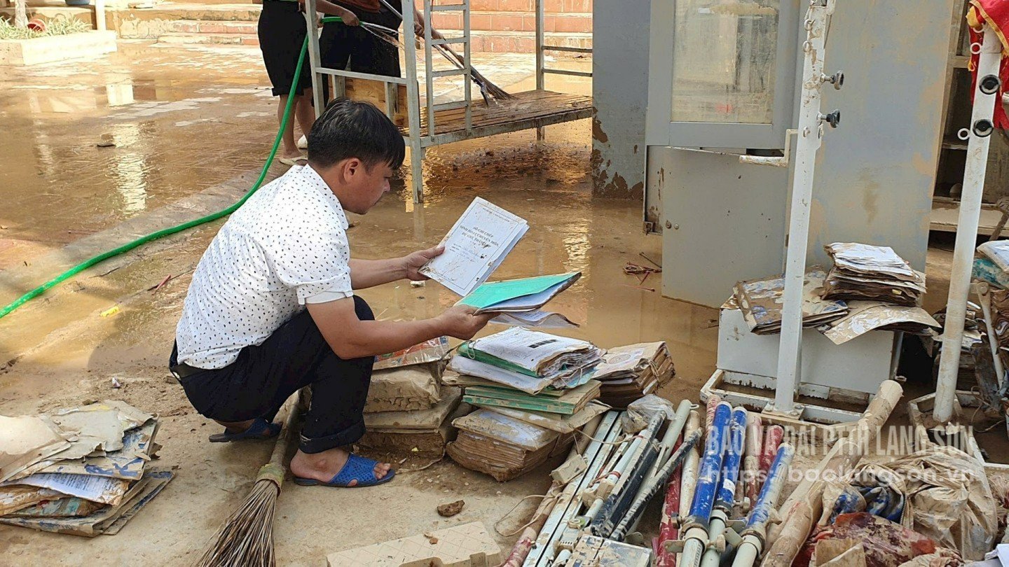 Lærer Hoang Huu Duong, rektor ved Yen Binh videregående skole, sjekker dokumenter og bøker som ble etterlatt etter flommen.