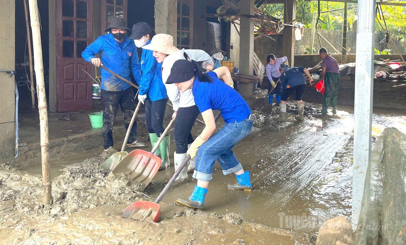 キムビン村の青年組合員は、嵐や洪水の後の泥の除去と被害の克服を支援する。