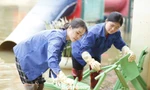 A teacher cleans up to welcome children to school. Photo: Nguyen Thang