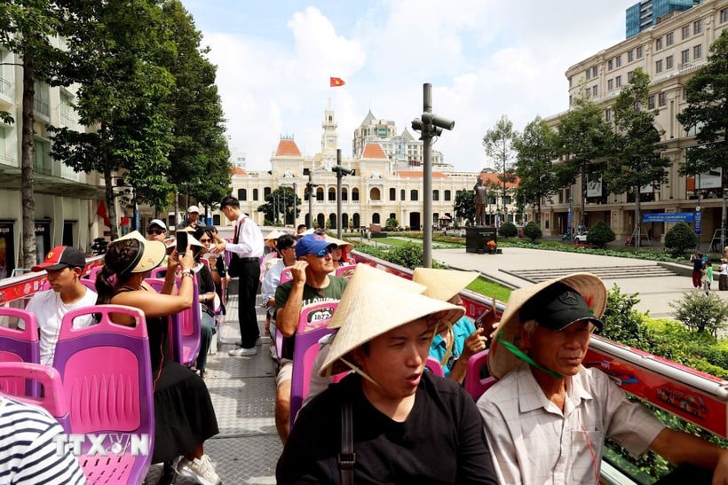 Zahraniční turisté navštěvují centrum Ho Či Minova Města dvoupatrovým autobusem. (Foto: Hong Dat/VNA)