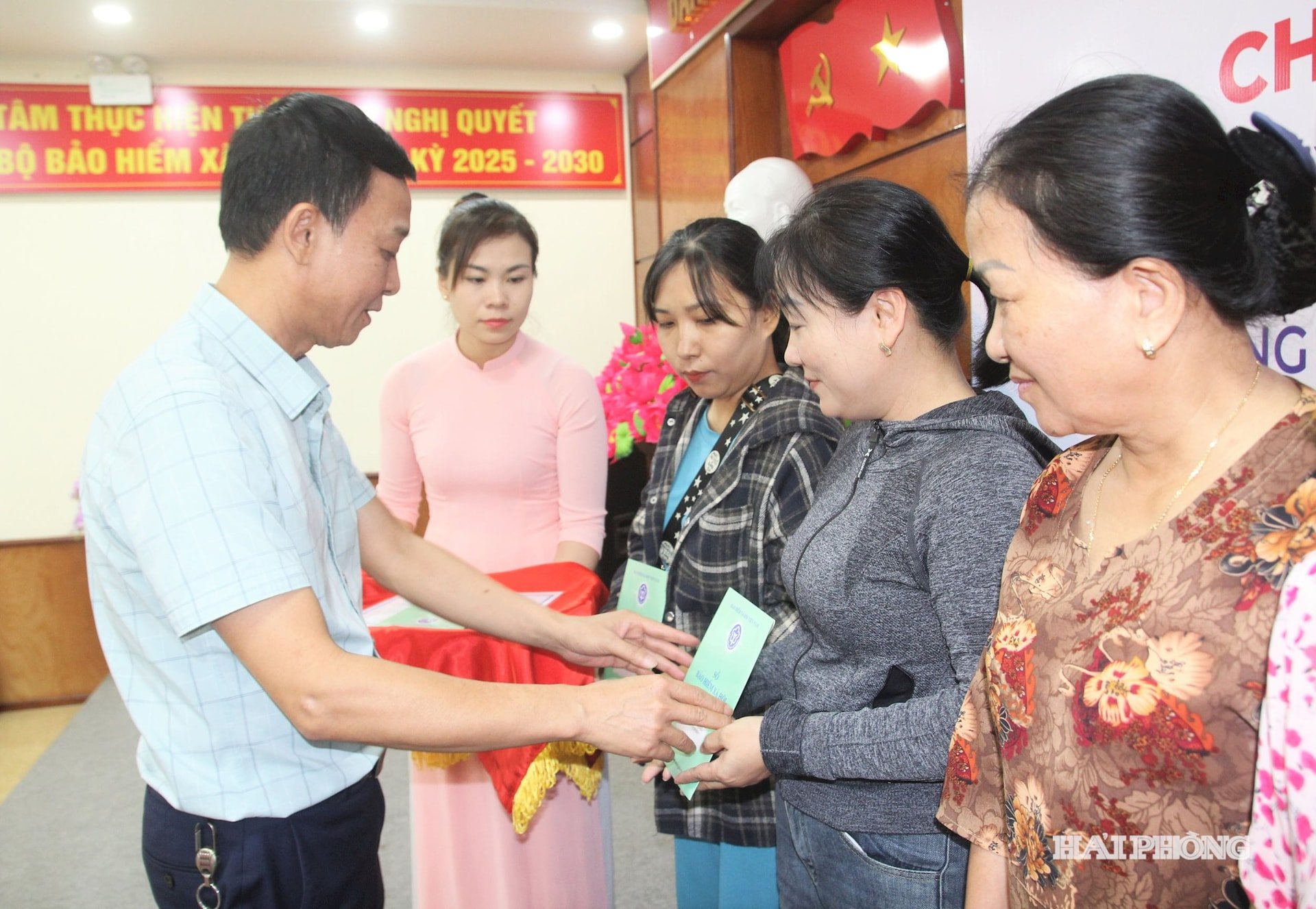 តំណាងថ្នាក់ដឹកនាំក្រុមហ៊ុនធានារ៉ាប់រងសង្គម Hai Phong បង្ហាញប័ណ្ណធានារ៉ាប់រងសុខភាពដល់សមាជិកនារីក្នុងស្ថានភាពលំបាក។