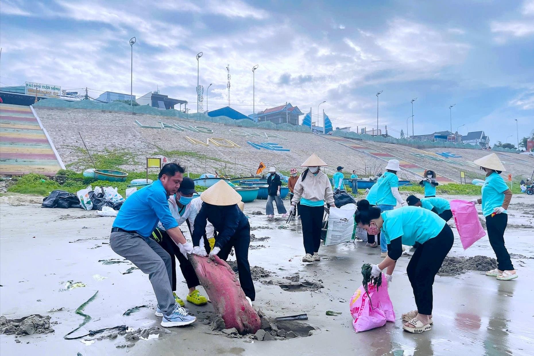 Moradores do bairro de La Gi, província de Lam Dong, recolhem lixo na praia, em resposta ao movimento de emulação 