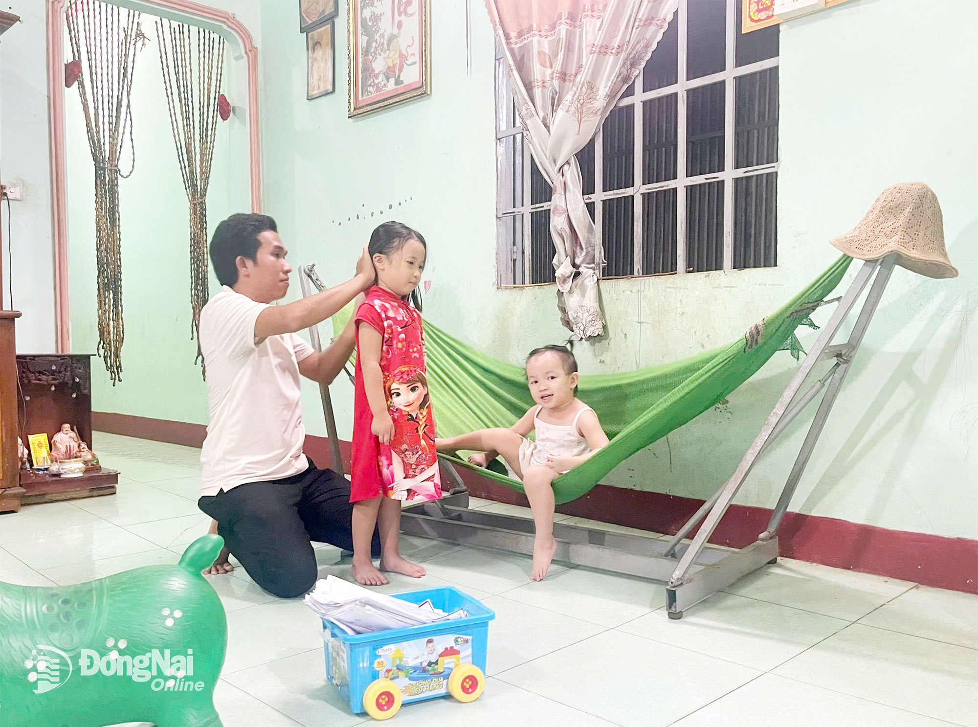 នៅ​ផ្ទះ​ខ្វះ​ដៃ​ស្ត្រី​ជា​រៀង​រាល់​ព្រឹក​ឬ​រសៀល លោក ដេត ម្នាក់​ឯង​មើល​ថែ​កូន​ស្រី និង​ប្អូន​ស្រី។ រូបថត៖ Thu Hien