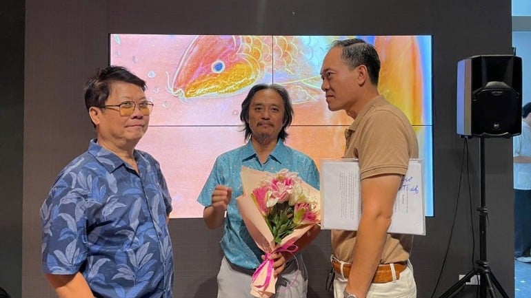 Maler Ngo Ba Hoang (Mitte) und Kollegen bei einer Ausstellung.