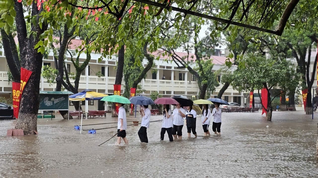 Học sinh một trường học ở Hà Nội ra về trong mưa ngập. Ảnh: NVCC.