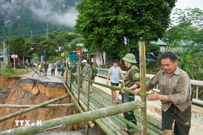 Local people and authorities promptly repaired the incident at the Son Thuy bridgehead on National Highway 16 at Km89+580 in Chung Son village, where the bridge foot and abutment were severely damaged, and the asphalt road surface, more than 10 meters long, collapsed completely. (Photo: VNA)