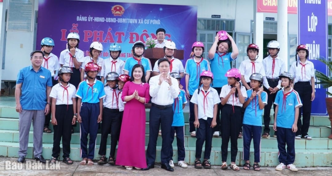 Lãnh đạo xã Cư Pơng tặng mũ bảo hiểm cho học sinh tại lễ phát động.