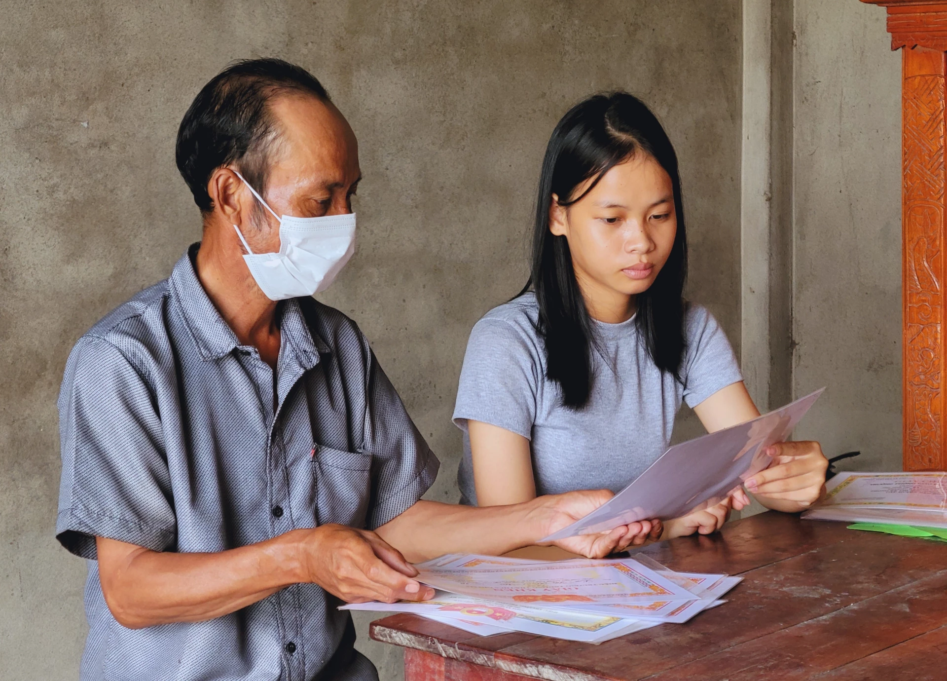 M. Quang écoute sa plus jeune fille, Le Thi My Tam, parler de ses études. Photo : T. Tuyen