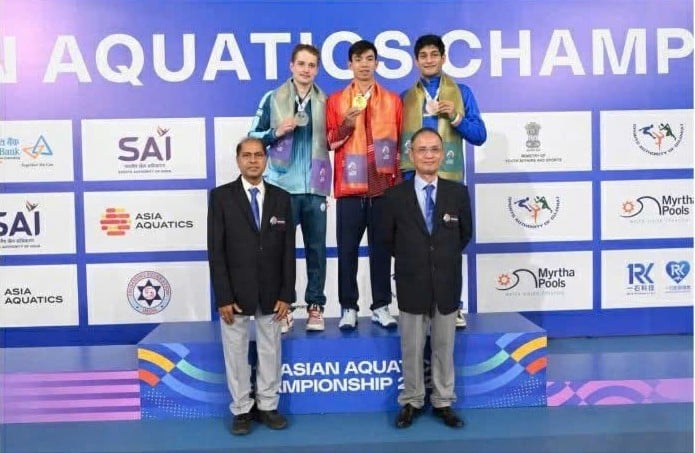 Huy Hoang se tient au milieu du podium et reçoit la médaille d'or asiatique.