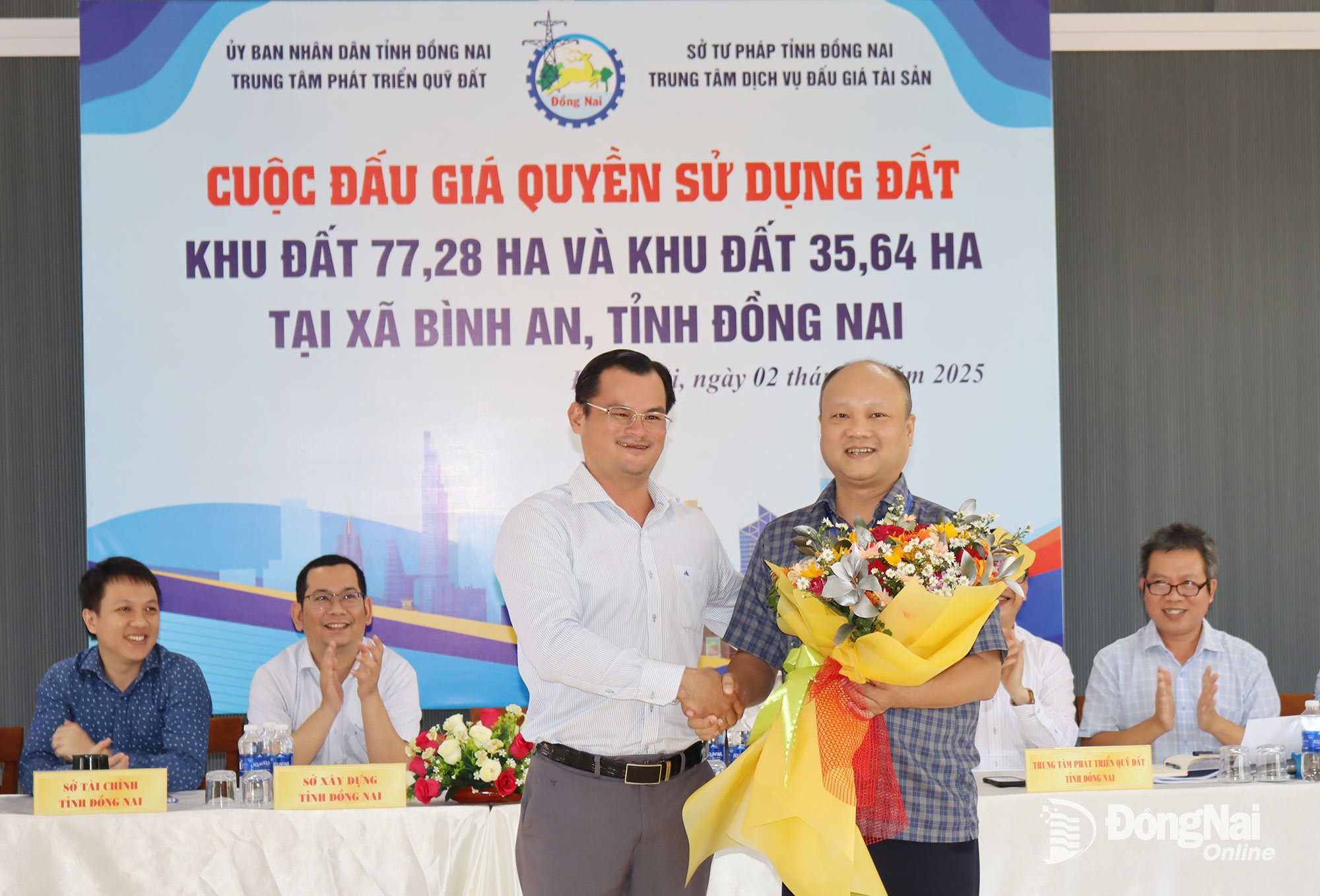 Ông Diệp Trường Vũ, Phó Giám đốc Sở Nông nghiệp và Môi trường tỉnh Đồng Nai tặng hoa chúc mừng khách hàng trúng đấu giá. Ảnh: Hoàng Lộc
