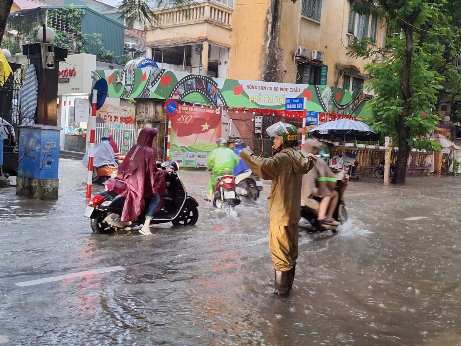 La policía del distrito de Ba Dinh dirige el tráfico en una zona inundada de la calle Quan Thanh. Foto: NS