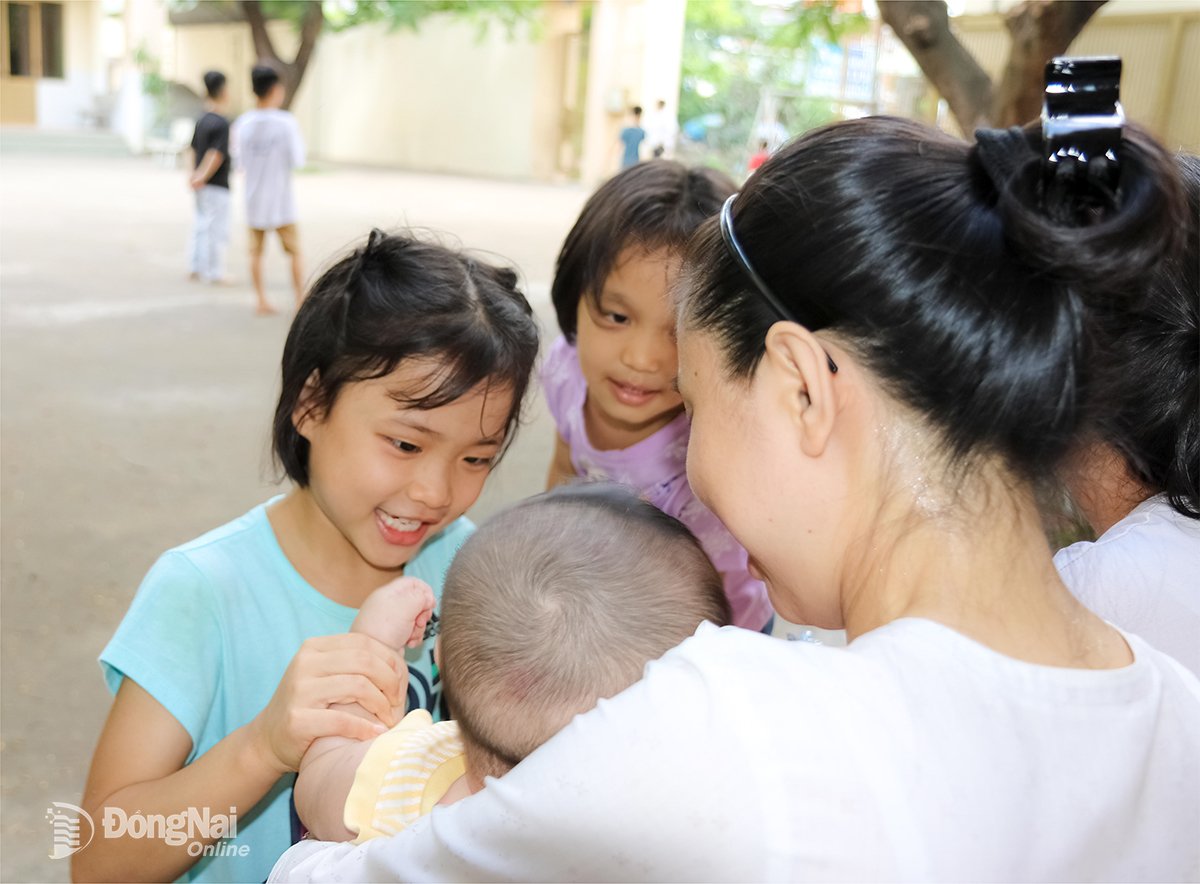 បងស្រី Bui Thi Hong Hanh ជាមួយកុមារដែលកំពុងមើលថែនៅមណ្ឌលកុមារកំព្រាទីក្រុងហាណូយ (វួដ Ho Nai)។ រូបថត៖ Van Truyen