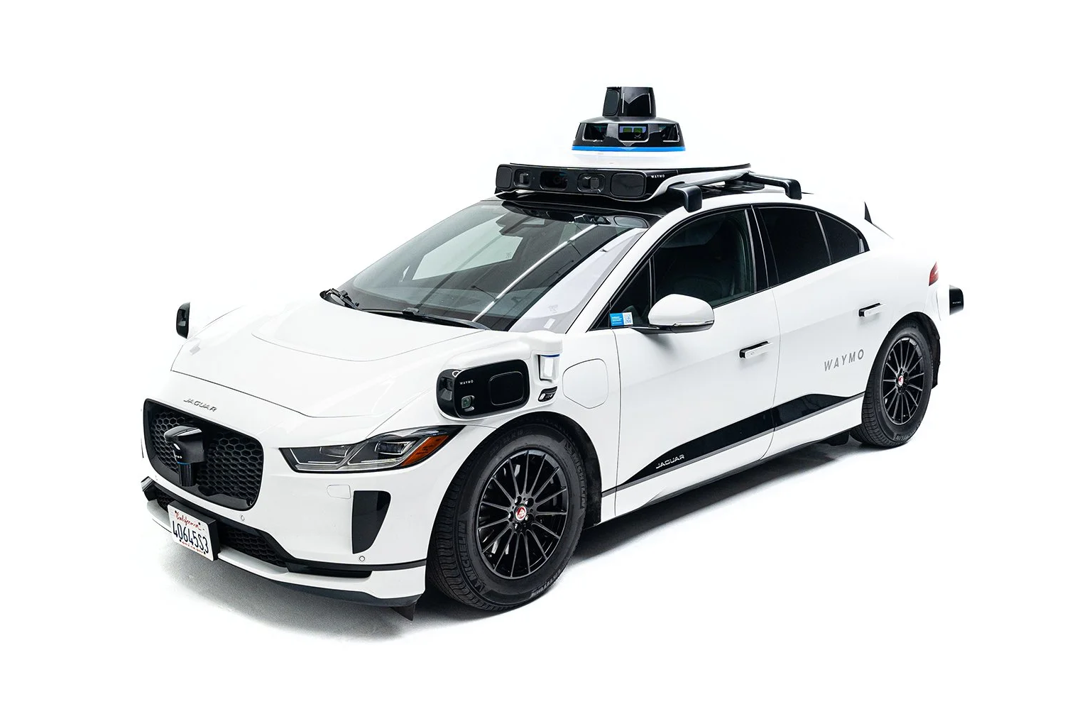سيارة جاكوار I-Pace ذاتية القيادة بيضاء اللون من Waymo مزودة بمجموعة أجهزة استشعار معقدة على سقفها.